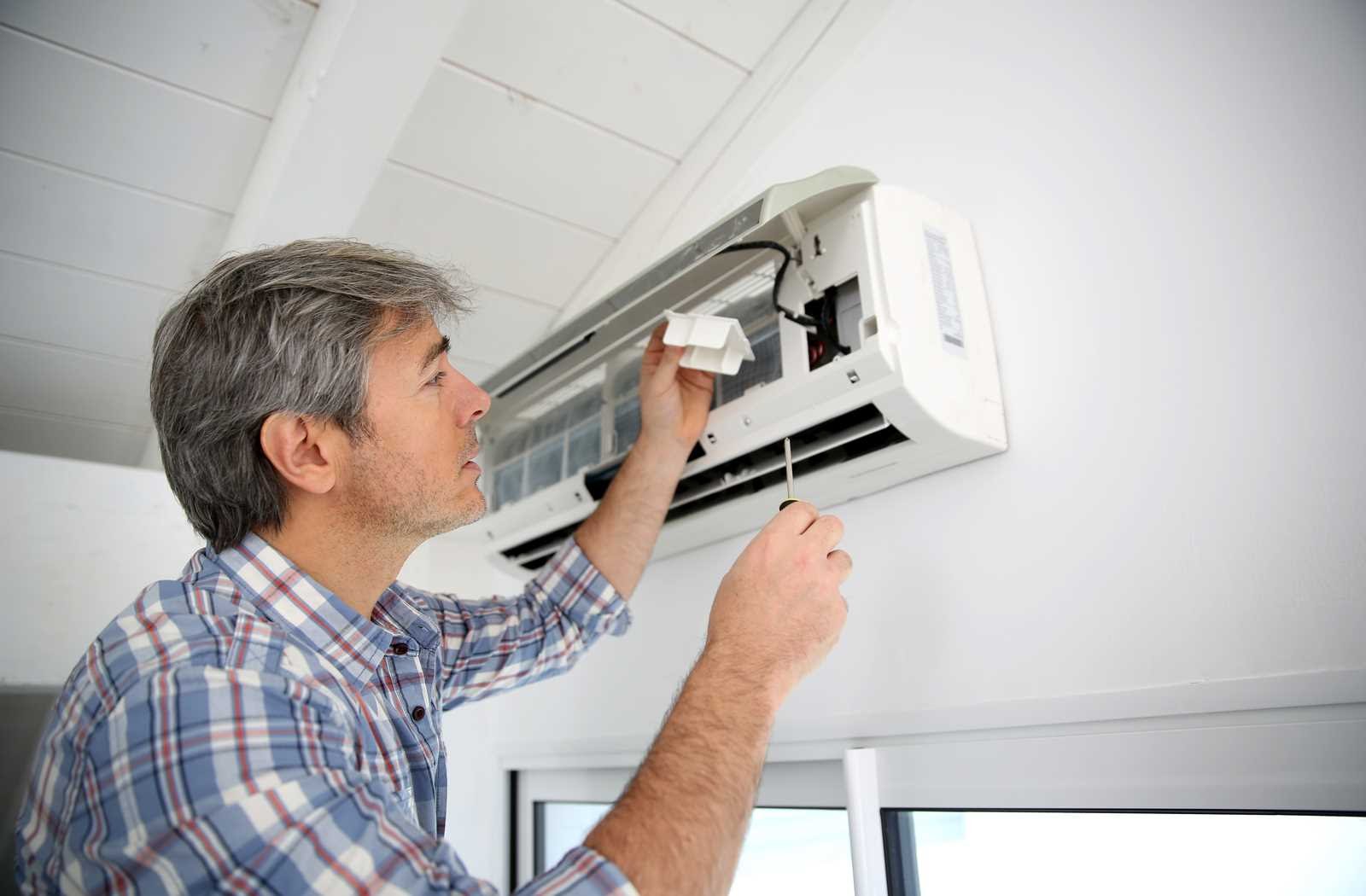 man working on ductless air conditioner